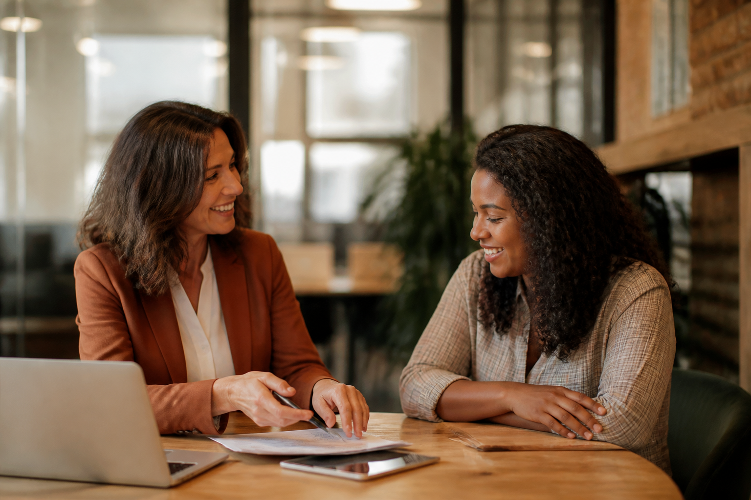 An HR lead explaining benefit options to an employee during a meeting in a UK office.